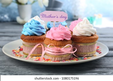 Tasty cupcakes and topper pick with words MOTHER'S DAY on table - Powered by Shutterstock