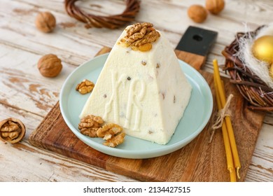 Tasty curd Easter cake with walnuts and candles on light wooden background