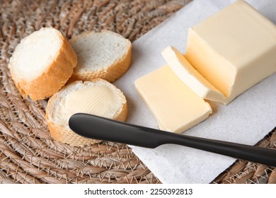 Baguette cortada con mantequilla fresca en estera de mimbre, enclavada