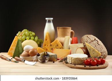 Tasty Dairy Products On Wooden Table, On Dark Background