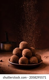 Tasty Dark Chocolate Truffles With Cocoa Dusting On A Brown Background