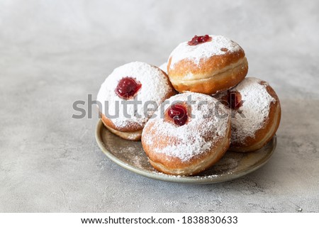 Tasty donuts with jam on wooden background - Hanukkah celebration concept