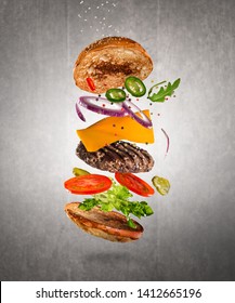 Tasty double cheeseburger with flying ingredients on dark background. High resolution image. - Shutterstock ID 1412665196