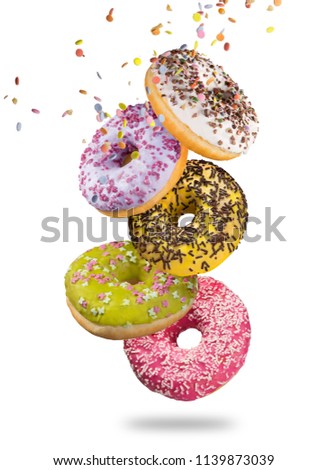 Tasty doughnuts in motion falling on white background, close-up.