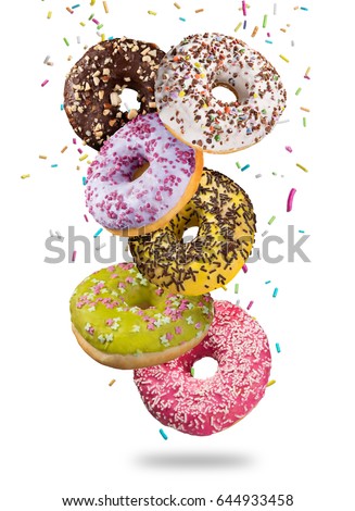 Tasty doughnuts in motion falling onwhite background, close-up.