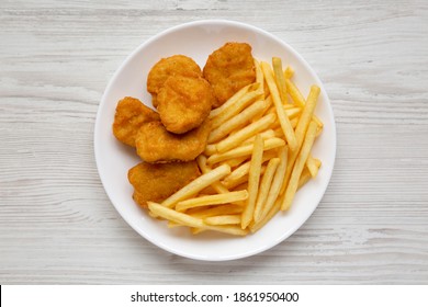 Tasty Fastfood: Chicken Nuggets And French Fries On A Plate On A White Wooden Background, Top View. Overhead, From Above, Flat Lay.