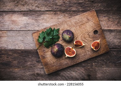 Tasty Figs on chopping board and wooden table. Autumn season food photo