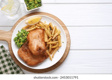 Tasty fish, chips, sauce, peas and lemon on white wooden table, top view. Space for text - Powered by Shutterstock