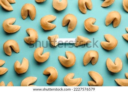 Tasty fortune cookies with predictions on light blue background, flat lay. Space for text