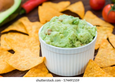 Tasty fresh guacamole with nachos in white bowl - Shutterstock ID 574491559