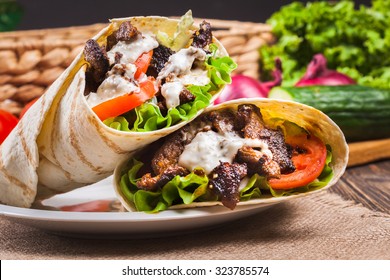 Tasty fresh wrap sandwich with beef, vegetables and tzatziki sauce