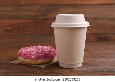 Tasty frosted donut with sprinkles and hot drink on wooden table - Powered by Shutterstock