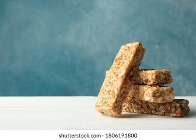 Tasty granola bars on white wooden table against blue background - Powered by Shutterstock