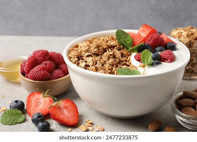 Tasty granola with berries and yogurt in bowl on grey table, closeup - Powered by Shutterstock