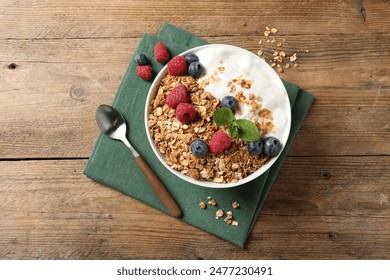 Tasty granola with berries and yogurt served on wooden table, top view - Powered by Shutterstock