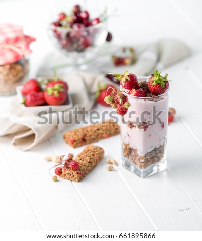Tasty granola with nuts and yoghurt, berries on the side, healthy breakfast, sideview