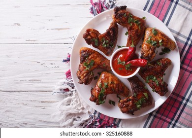 Tasty Grilled Chicken Wings With Sauce Chilli Close-up On A Plate. Horizontal View From Above
