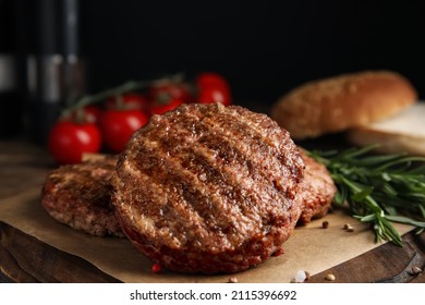 Tasty grilled hamburger patties with seasonings on wooden table, closeup - Shutterstock ID 2115396692