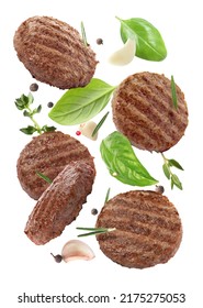 Tasty grilled hamburger patties and spices falling on white background