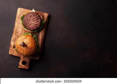 Tasty grilled home made burgers with beef, tomato, cheese, cucumber and lettuce. Top view with space for your recipe - Powered by Shutterstock