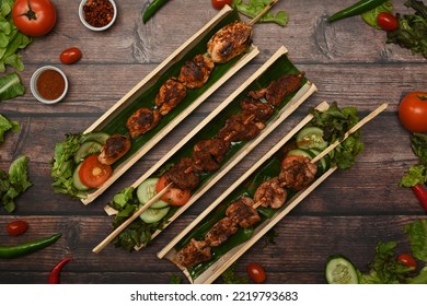 Tasty Grilled Meat With Sichuan Pepper In Bamboo Barrel Plate Surrounded By Vegetable On Rustic Wooden Table