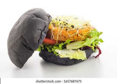 Tasty Grilled Veggie Burger With Chickpeas And Vegetables On Black Bread On White Background.