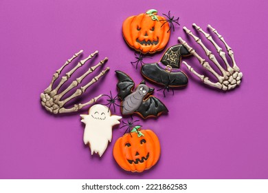 Tasty Halloween Cookies And Skeleton Hands On Purple Background