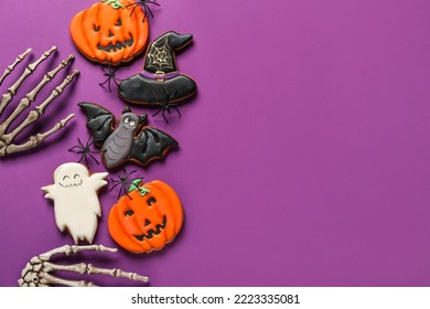 Tasty Halloween Cookies And Skeleton Hands On Purple Background