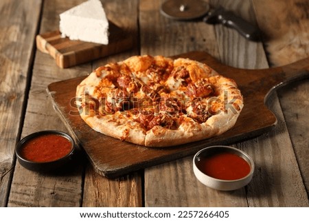 Tasty hawaiian pizza with chicken on wooden cutting board. Horizontal
