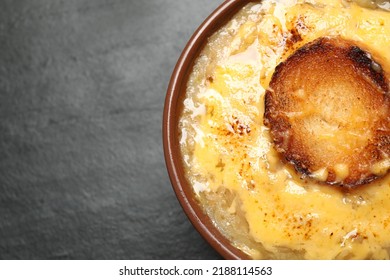 Tasty Homemade French Onion Soup On Black Table, Top View. Space For Text