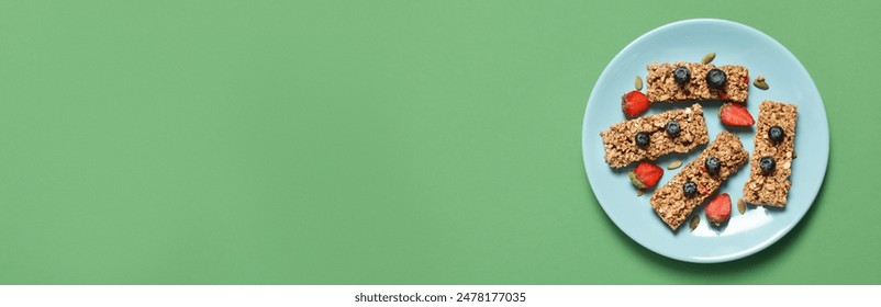 Tasty homemade granola bars and berries on light green table, top view. Banner design with space for text - Powered by Shutterstock