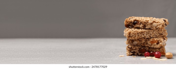 Tasty homemade granola bars on grey wooden table. Banner design with space for text - Powered by Shutterstock