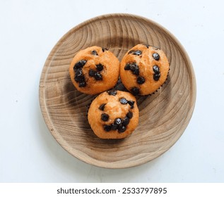 Tasty homemade soft, sweet and delicious banana chocolate chip muffins ,
Banana Cake,banana cup cake isolate on a  wooden plate on a white backdrop, top view. Space for text - Powered by Shutterstock