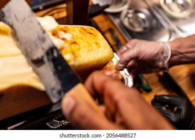 Tasty hot cheese is scooped onto a potato