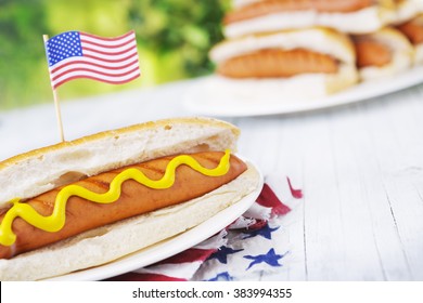 A tasty hot dog with mustard on an outdoor table. - Powered by Shutterstock