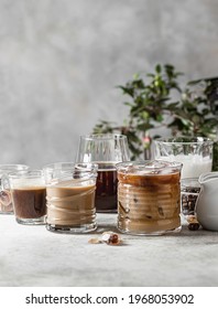 Tasty ice coffee with milk, cream and set with different types of coffee drinkson gray background with copy space. Ice coffee with milk, espresso, cappuccino and mocha coffee. Cold summer drink.