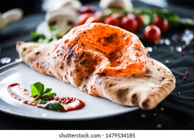 tasty italian calzone pizza with fresh ingredients and vegetables - Shutterstock ID 1479534185