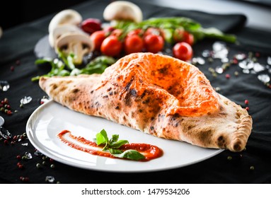 tasty italian calzone pizza with fresh ingredients and vegetables - Shutterstock ID 1479534206