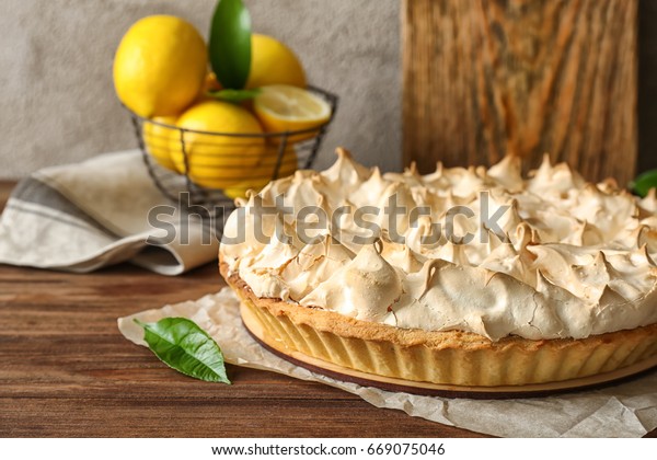 Tasty lemon
meringue pie on wooden table,
closeup