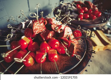 Tasty little beer snacks with salami sausages, cheese and cherry tomato on sticks in cafe - Shutterstock ID 1202191705