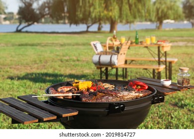 Tasty meat and vegetables on barbecue grill outdoors. Space for text