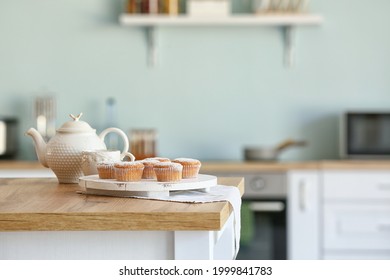 Tasty Muffins With Tea On Kitchen Table