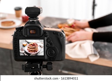 Tasty Pancakes On Display Of Professional Photo Camera In Studio