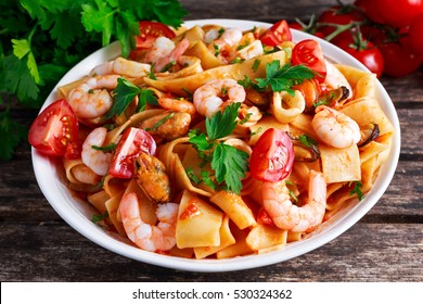 Tasty Pappardelle Pasta With Shrimp, Squid, Mussel, Tomatoes And Herbs.