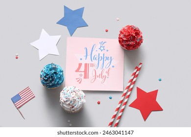 Tasty patriotic cupcakes with stars and greeting card on grey background. American Independence Day - Powered by Shutterstock