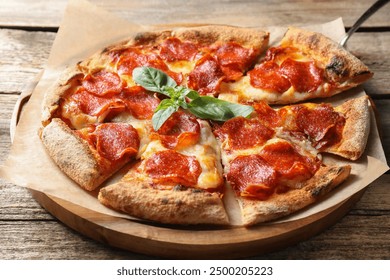 Tasty pepperoni pizza with basil on wooden table - Powered by Shutterstock