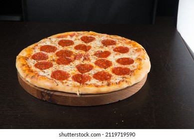 Tasty pepperoni pizza and cooking ingredients tomatoes basil on black concrete background. Top view of hot pepperoni pizza. Banner - Shutterstock ID 2119719590