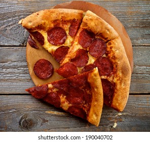 Tasty Pepperoni Pizza With Slice Of Salami On Wooden Plate Closeup On Rustic Wooden Background. Top View