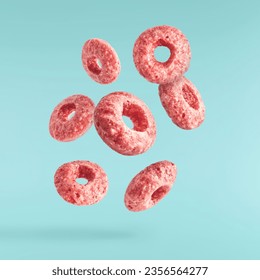 Tasty pink ring Cereals falling in the air isolated on blue background. Food levitation conception. High resolution image - Powered by Shutterstock