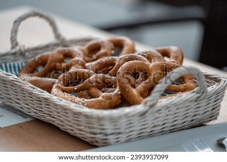 Tasty pretzels in a basket on the wooden table